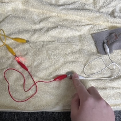 Im making sure its not an issue with weak connection on the conductive thread here and realized that it was invisible on the carpet so I moved everything onto a yellow towel so that I'd stop loosing things.